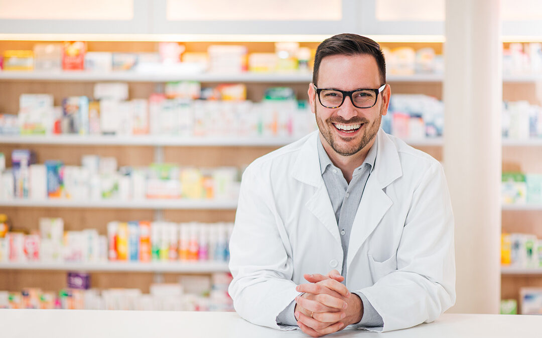 Portrait of a cheerful young pharmacist leaning on a counter