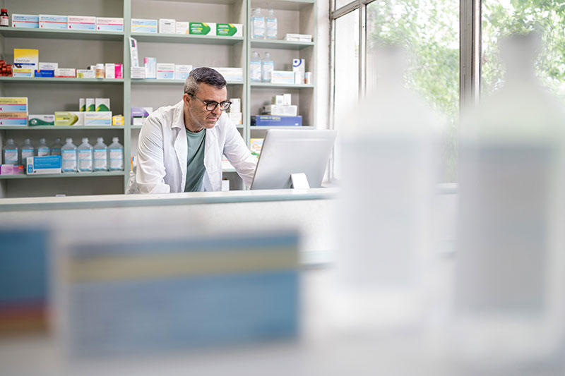 Pharmacist working on computer at a pharmacy