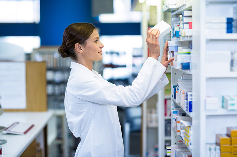 Pharmacist checking medicine on shelf